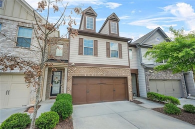 Multi unit property with driveway, a garage, and brick siding