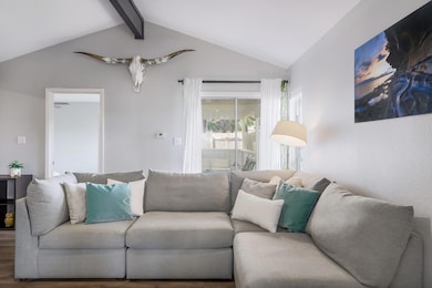 Living room featuring lofted ceiling with beams a