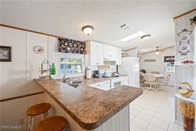 Kitchen with white electric range oven, a peninsul