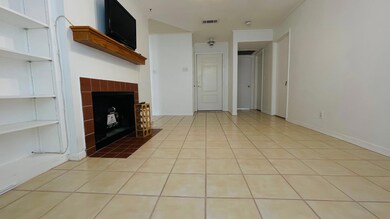 Unfurnished living room with light tile patterned flooring and a tiled fireplace