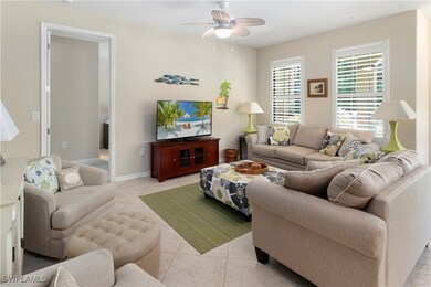 Living room with ceiling fan and light tile patter