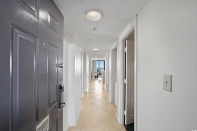Hall with a textured ceiling and light tile patter