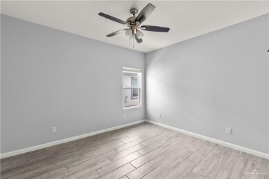 Spare room featuring a ceiling fan, wood finished floors, and baseboards