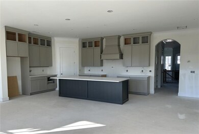 Kitchen with a kitchen island, custom exhaust hood