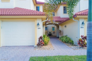 View of front of house with stucco siding, a garage, and a tiled roof