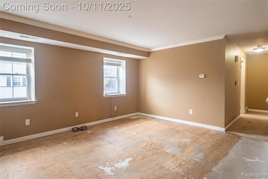 Spare room with baseboards and crown molding