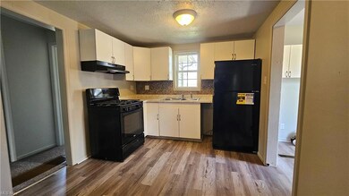 Kitchen with a textured ceiling, backsplash, black