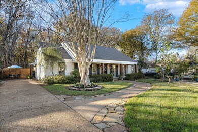 View of front facade with a front yard and covered
