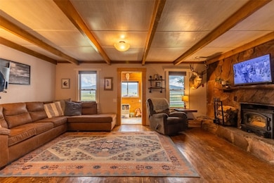 Living room with beamed ceiling, hardwood / wood-s