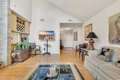 Living area featuring high vaulted ceiling, wood f