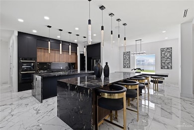Kitchen featuring a spacious island, modern cabinets, light marble finish floors, tasteful backsplash, and recessed lighting