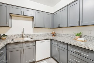 Kitchen featuring light stone counters, gray cabin
