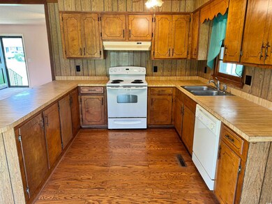 Kitchen with sink, white appliances, dark hardwood