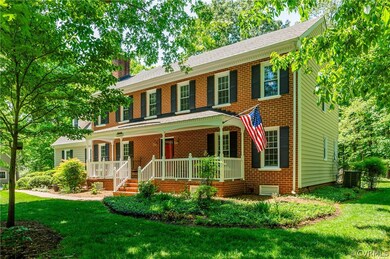 Colonial house featuring a porch, and a front yard