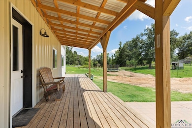 Wooden deck with a trampoline, a lawn, and a patio