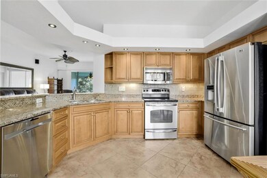 Kitchen with light tile flooring, granite counters, and stainless steel appliances