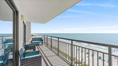 Balcony featuring view of water and beach