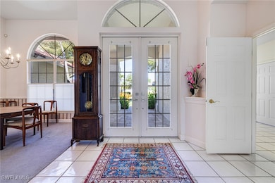 Foyer entrance with french doors, light colored ca