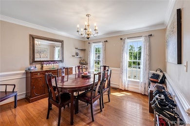 Dining space with a chandelier, crown molding, and