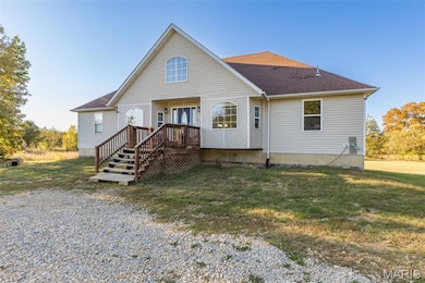 Rear view of property featuring a lawn and a shingled roof
