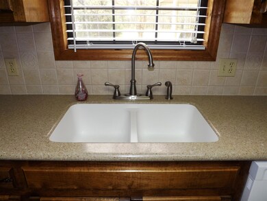 The kitchen has a sunny window over the sink featuring solid surface counters with molded double sink.