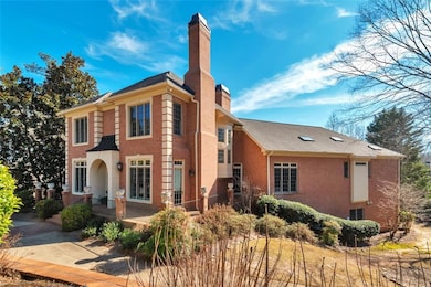 View of front facade with a porch, a chimney, and stucco siding