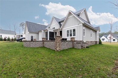Rear view of property featuring yard and paver and