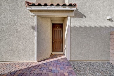 View of exterior entry with a tiled roof and stucc