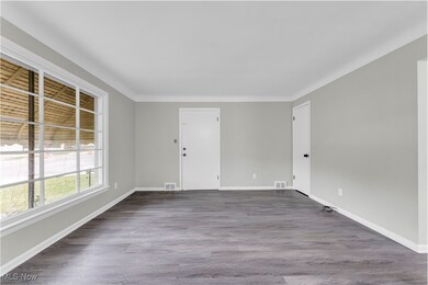 Spare room featuring baseboards, visible vents, and dark wood-style flooring