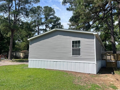 View of side of home featuring a yard and a wooden deck