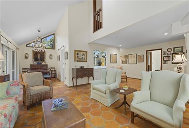 Living room with a chandelier, high vaulted ceiling, and tile patterned flooring
