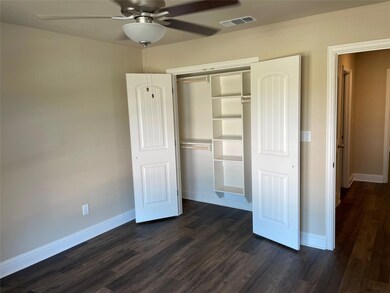 Unfurnished bedroom with ceiling fan, a closet, and dark hardwood / wood-style floors