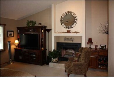 The living room features vaulted ceilings and a wo