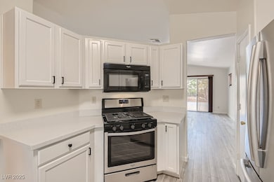 Kitchen with stainless steel appliances, white cab
