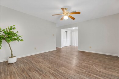 Empty room featuring ceiling fan and dark hardwood