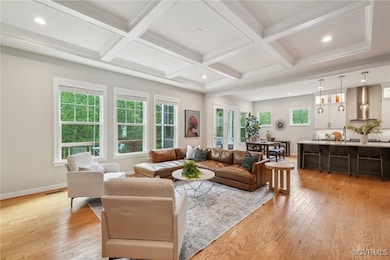 Living room featuring beamed ceiling, light wood-s