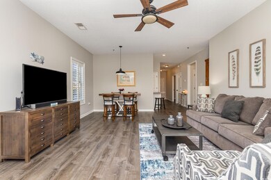 Living area featuring visible vents, ceiling fan, baseboards, and wood finished floors