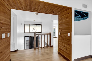 Entrance foyer with wooden walls, visible vents, 