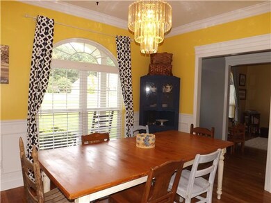 The formal dining room has a sunny arched window, hardwood floors and space for a large harvest dining table.