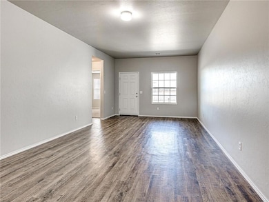 Empty room with baseboards and dark wood-style flo