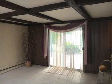 Living Room With Decorative Beams and Access To Re