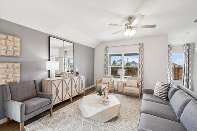 Living room featuring wood finished floors, a ceiling fan, and vaulted ceiling