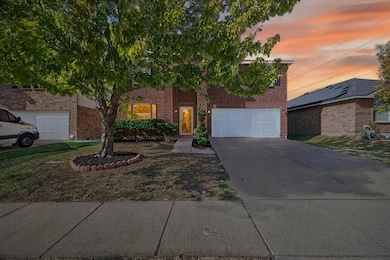 View of front of property featuring driveway, brick siding, and a garage
