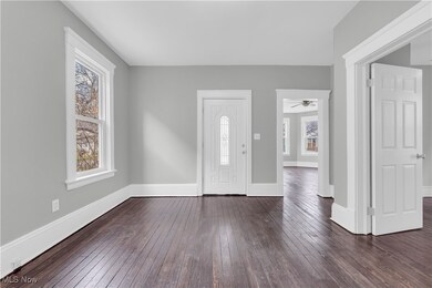 Entrance foyer featuring a ceiling fan, baseboards, and dark wood-style flooring