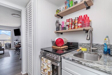 Kitchen featuring a sink, open shelves, white cabi