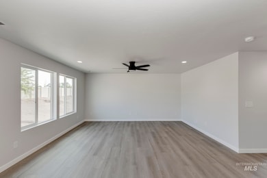Spare room with light wood finished floors, ceiling fan, and recessed lighting