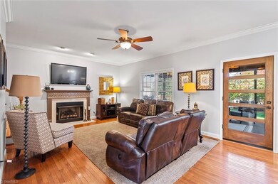 Family room/Den is open to the kitchen and breakfast room and features a gas fireplace, hardwood flooring, and crown molding.  Door shown is new and leads to the screen porch.
