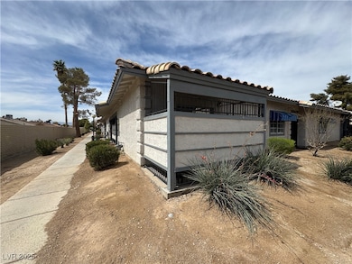 View of side of home with a tile roof, fence, and