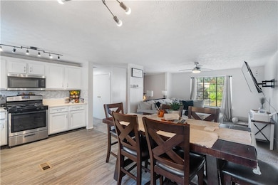 Dining space with visible vents, a textured ceilin