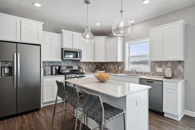 Enjoy plenty of seating at the kitchen island and dining area adjacent to the kitchen. Perfect for entertaining or having a family meal together. (Photo of decorated model, actual home's finishes may vary slightly)